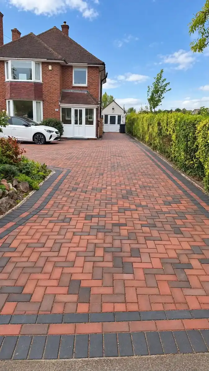 Long red block-paved driveway leading to a detached garage